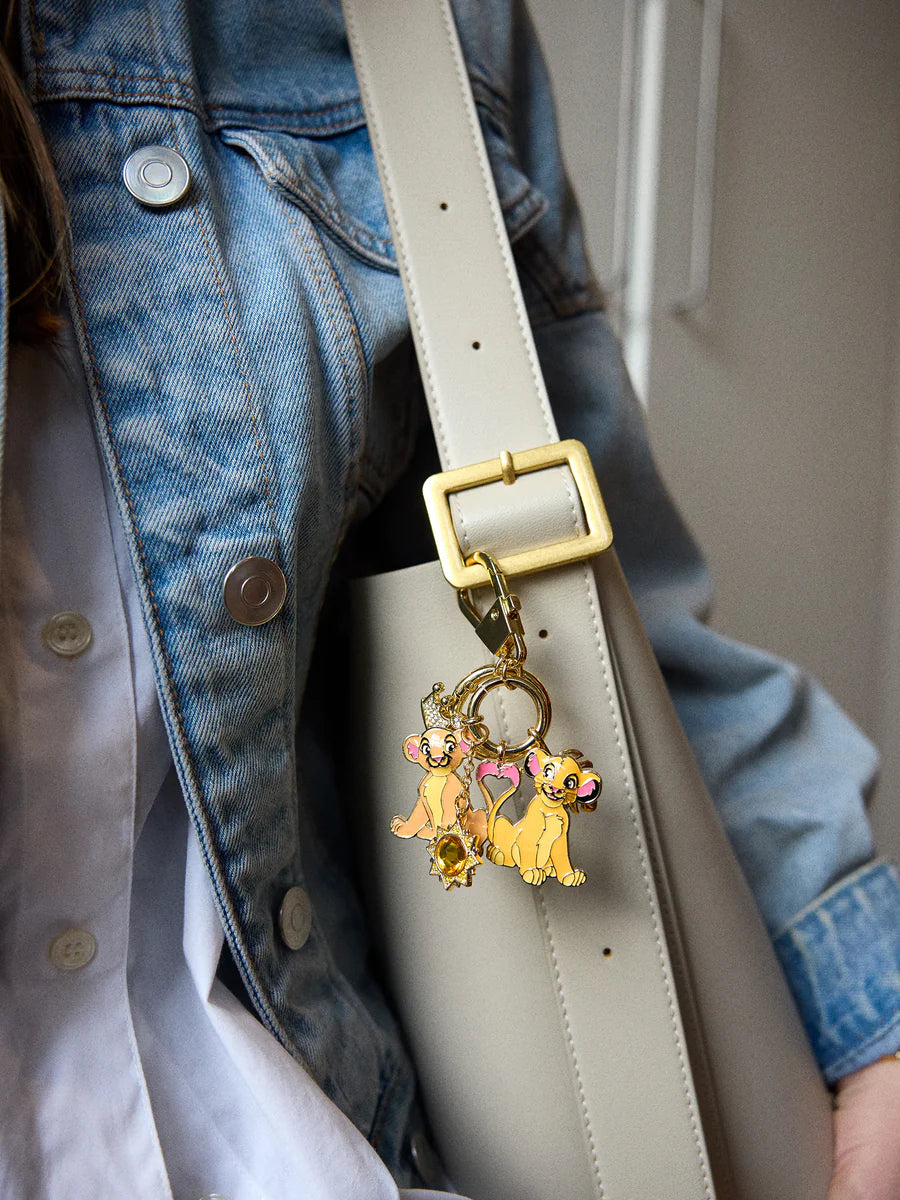 Keychain with Simba and Nala from 'The Lion King' clipped on a grey purse