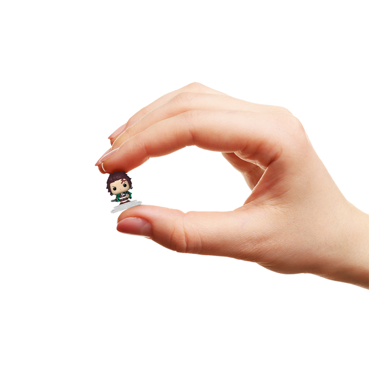 Hand holding a small figurine against a white background