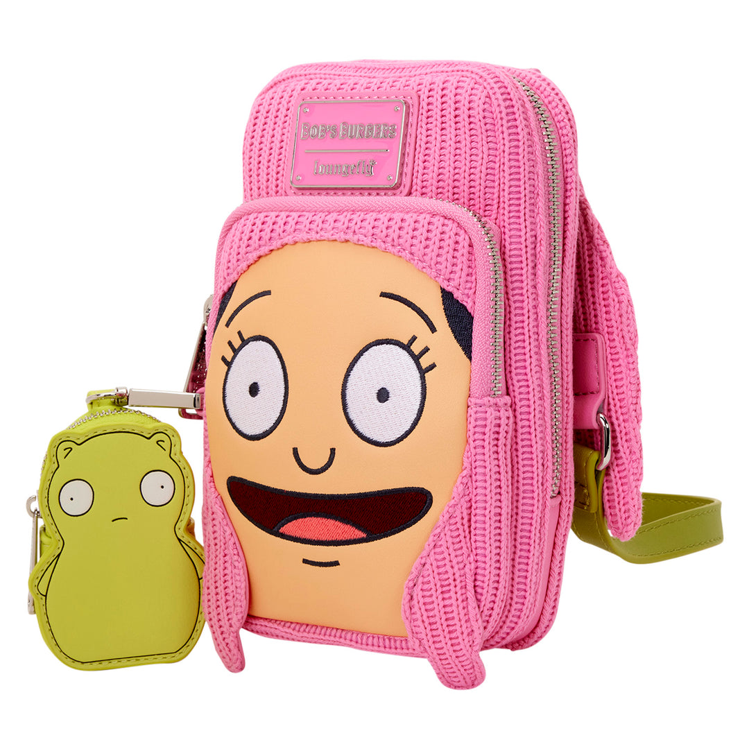 Pink crossbody bag with cartoon face design and small green pouch on a white background