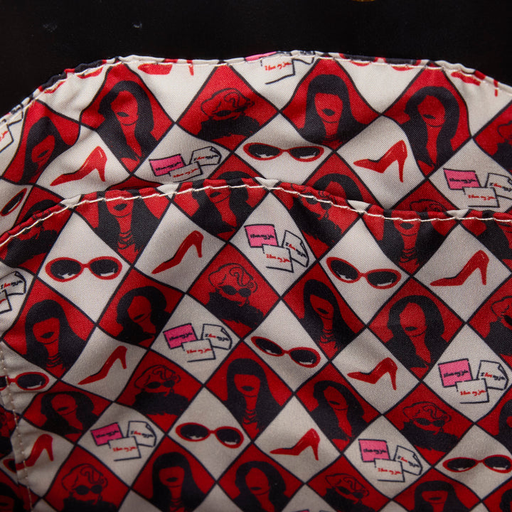 Patterned fabric with red, black, and white design on a dark background