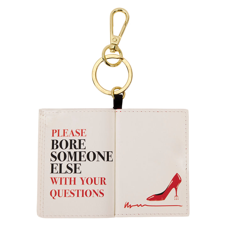 Keychain with open book design and high heel illustration on a white background