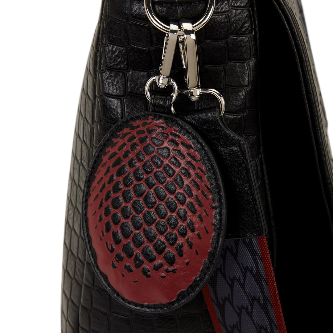 Black textured bag with a red and black patterned keychain attached