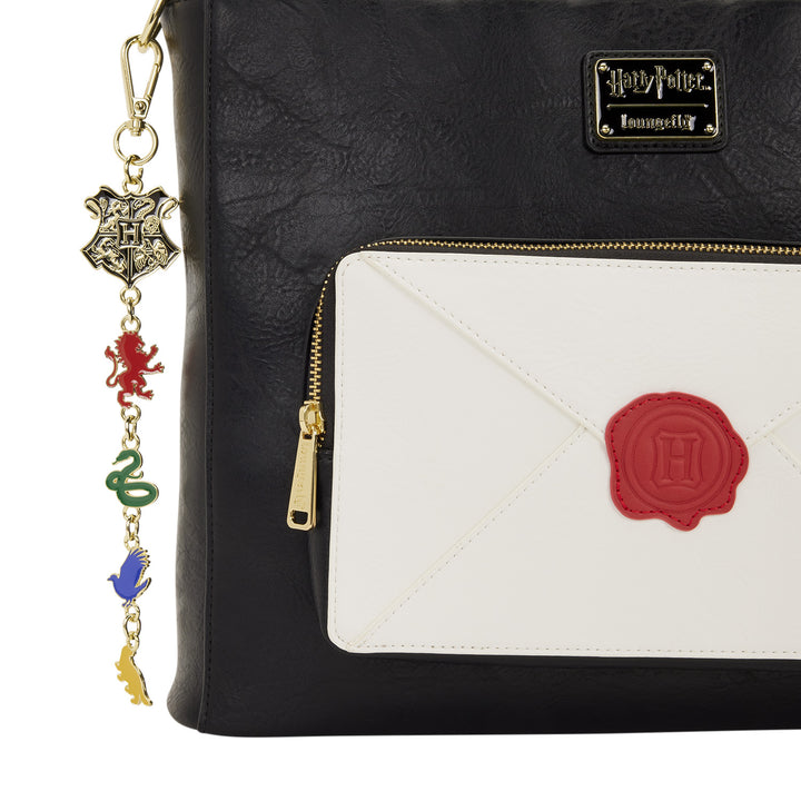 Black bag with a white envelope design and red 'H' emblem, featuring a Harry Potter charm.