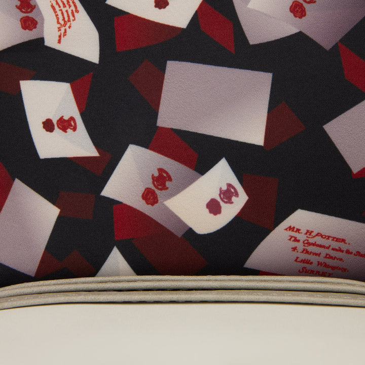 Patterned fabric with red and white shapes on a black background, resembling playing cards.