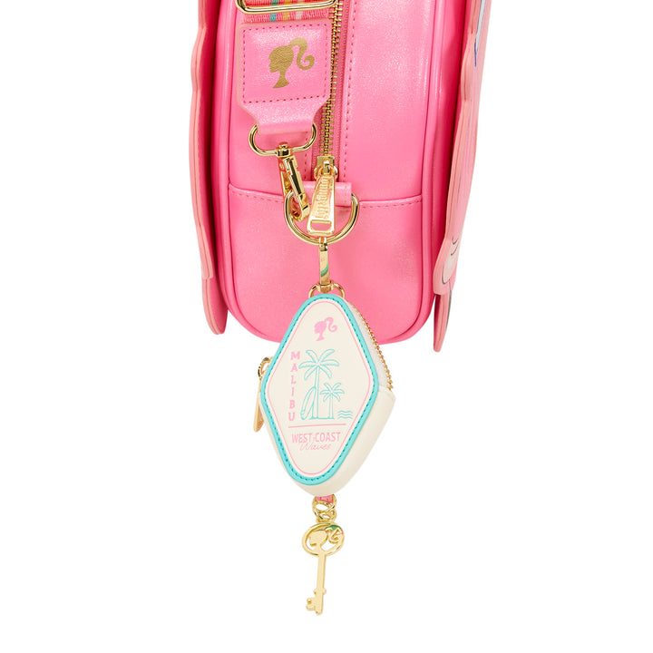 Pink bag with a decorative keychain featuring a palm tree and key design on a white background