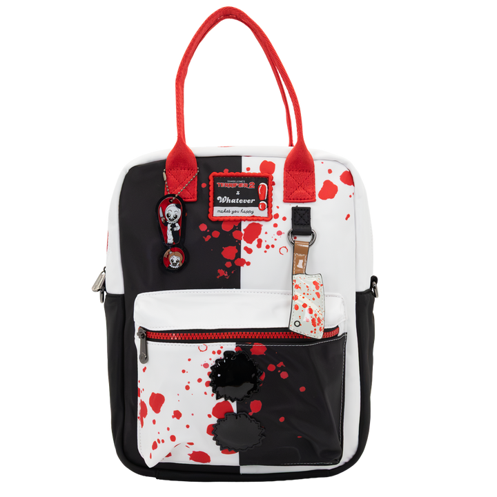 A white and black backpack with red handles and red blood-splatter print, featuring a front zip pocket with a black flower applique and a 'Whatever' brand patch.