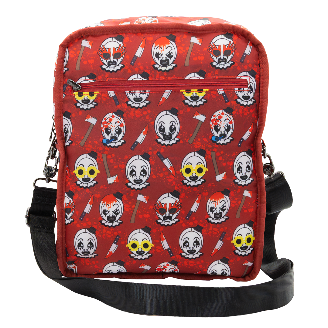 A red crossbody bag featuring a repeating horror clown and axe print, with a black adjustable strap and a front zippered pocket.