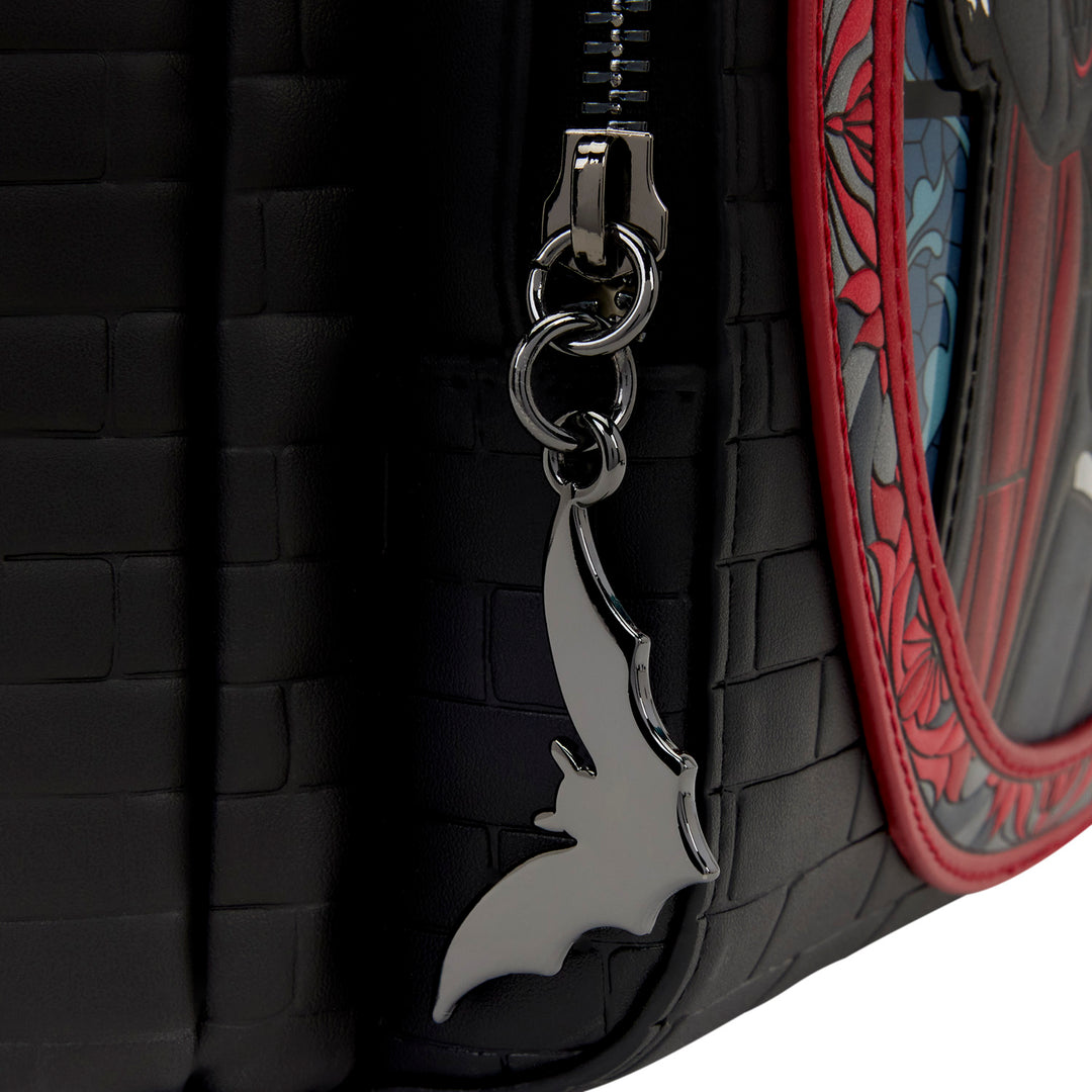 Keychain with a bat design attached to a black textured surface