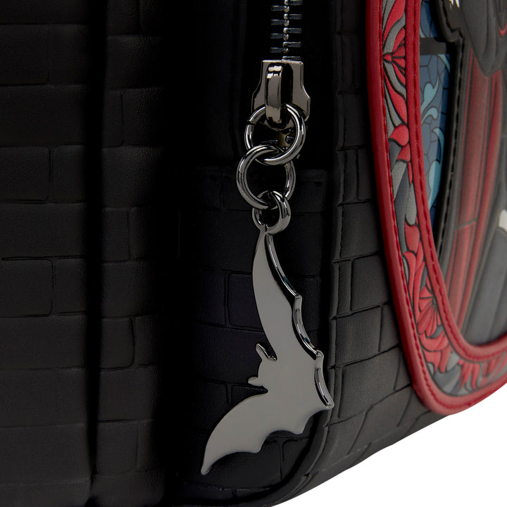 Keychain with a bat design attached to a black textured surface