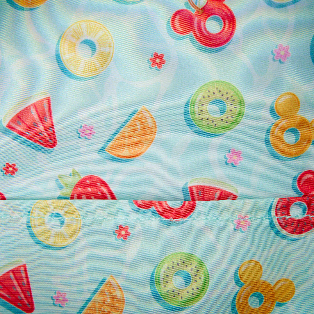 Fabric with colorful fruit and swim ring pattern on a light blue background