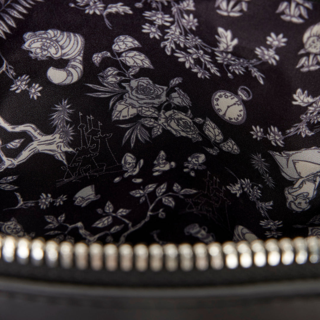 Close-up of a black fabric with white floral and clock design, zipper visible.