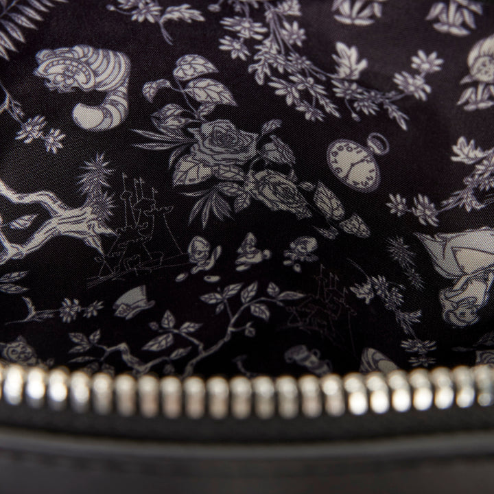 Close-up of a black fabric with white floral and clock design, zipper visible.