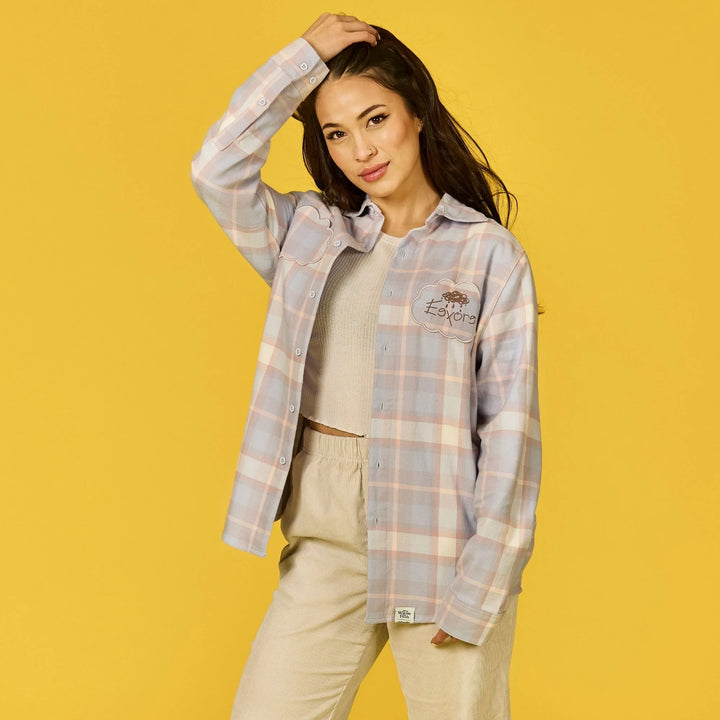 Woman wearing a plaid shirt and beige pants on a yellow background