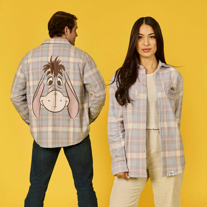Two people wearing plaid shirts with cartoon character designs on a yellow background