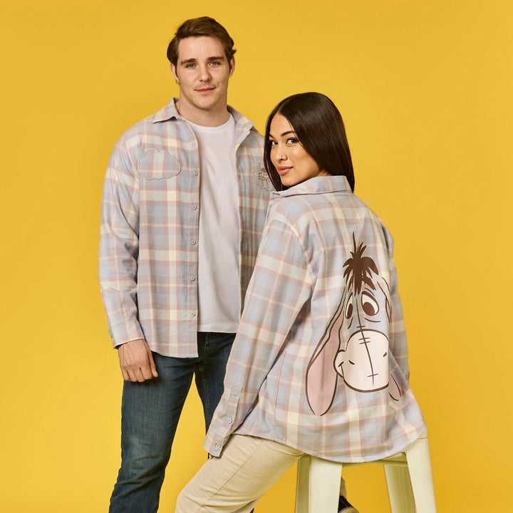 Two people wearing plaid shirts with cartoon character designs on a yellow background