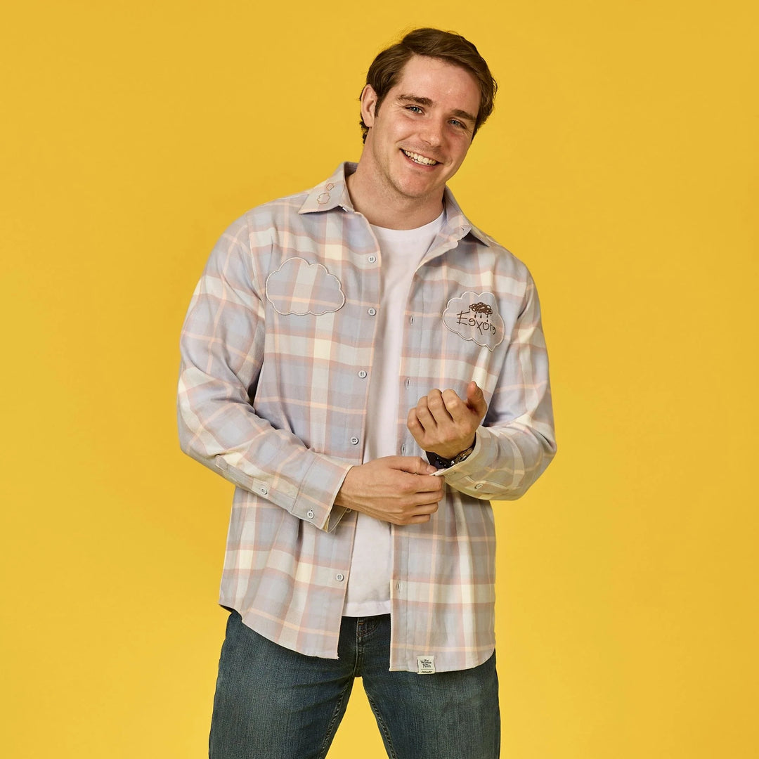 Man wearing a plaid shirt over a white t-shirt on a yellow background
