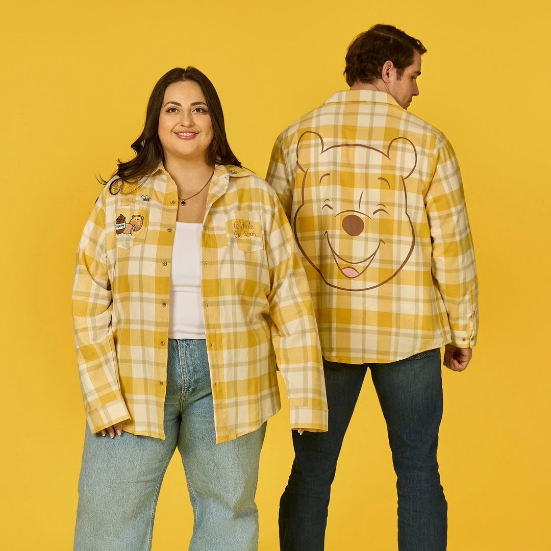 Two people wearing yellow plaid shirts with cartoon bear designs on a yellow background