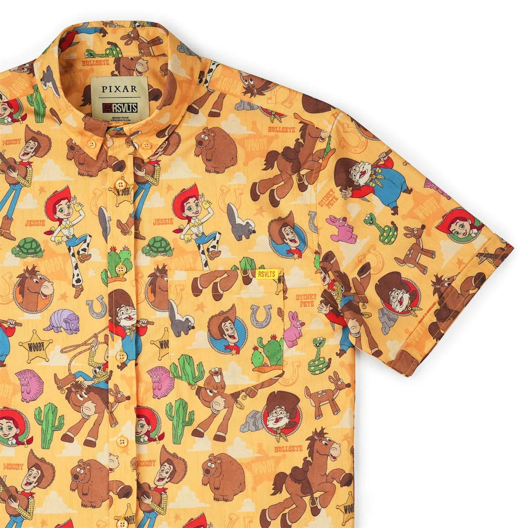 A short-sleeve button-up shirt featuring an all-over cartoon print from Pixar's Toy Story, displayed on a clean white background.