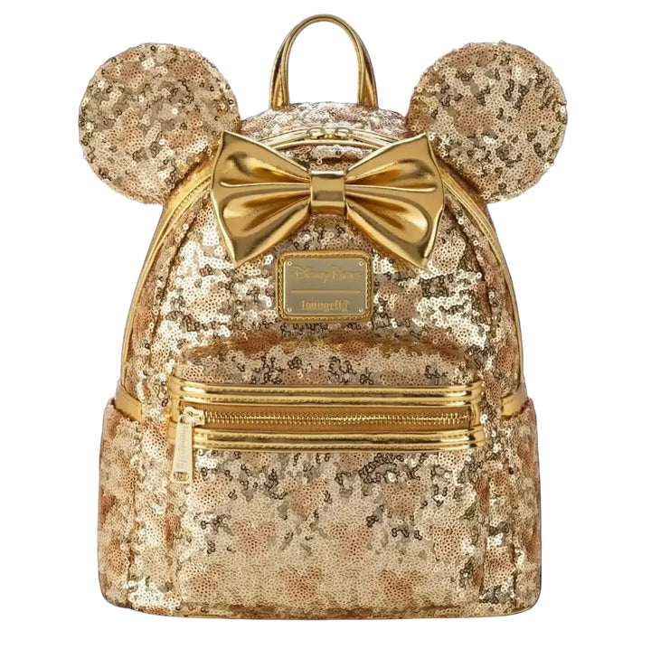A gold sequined mini backpack with mouse ears, a large bow, and a front zip pocket, shown against a solid black background.
